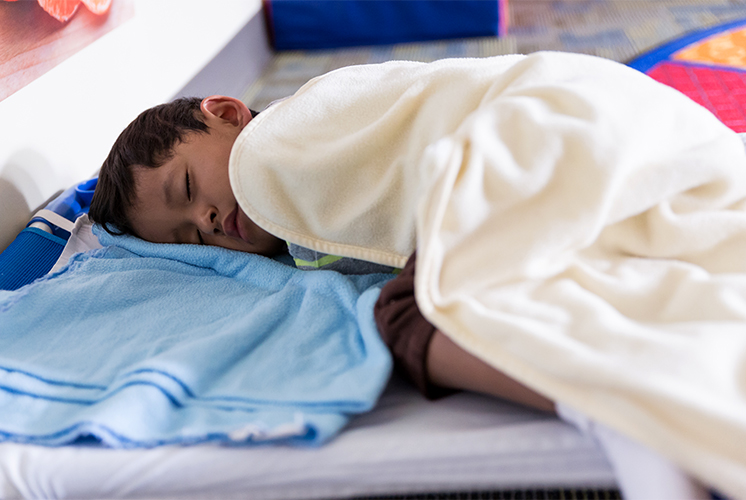 Un niño duerme bajo una cobija