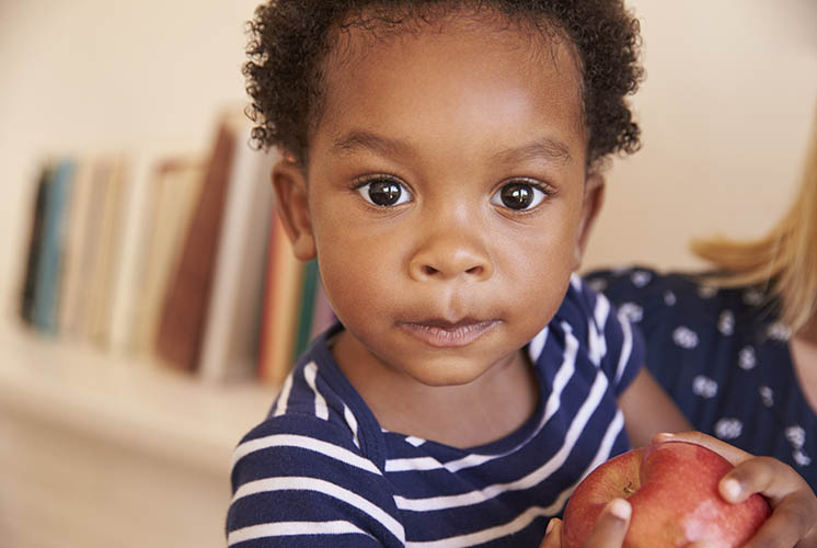 un niño está sosteniendo una manzana