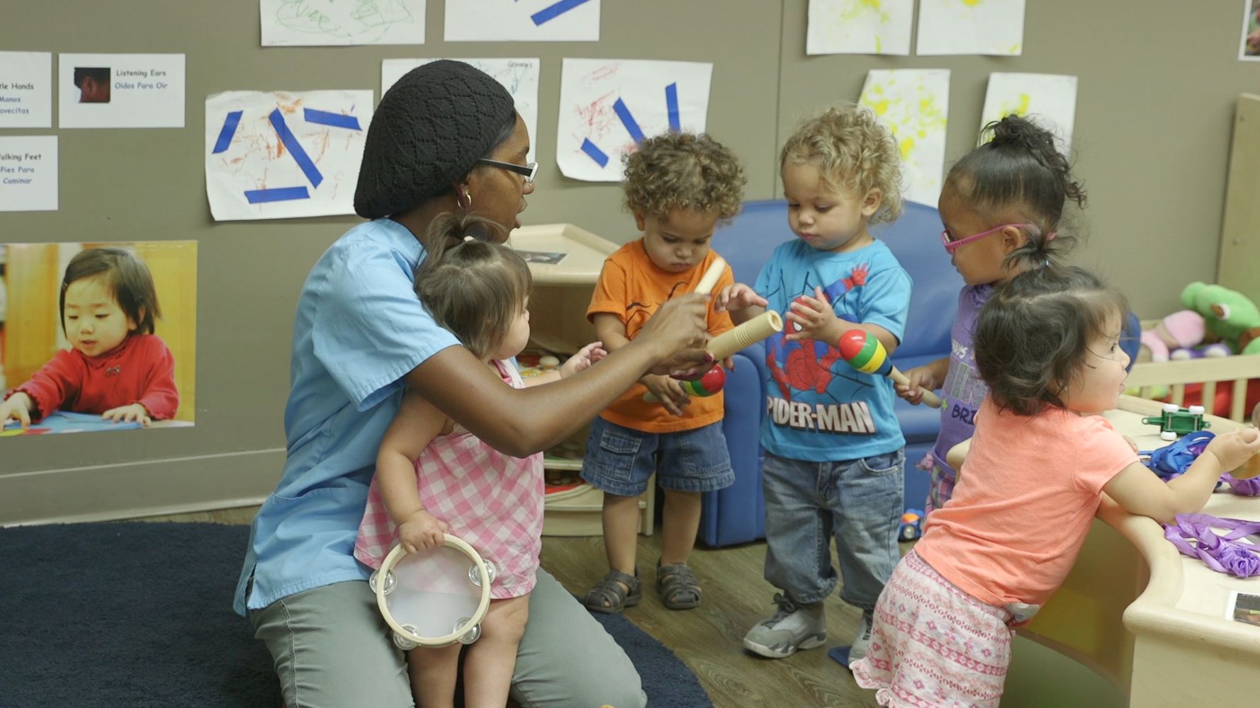 Maestra supervisando a niños con instrumentos musicales.