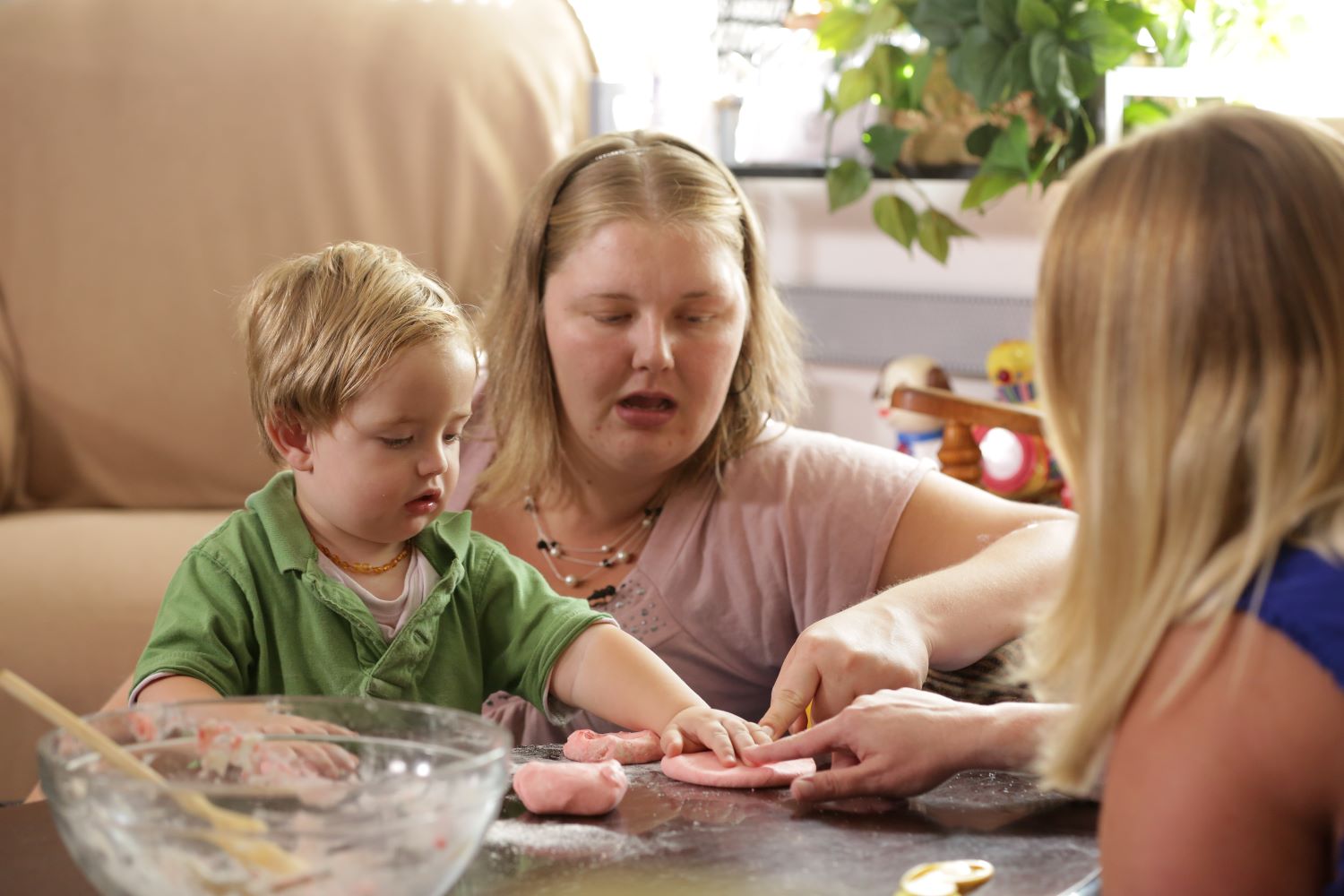 Chidren shaping clay into round burger-like patties.