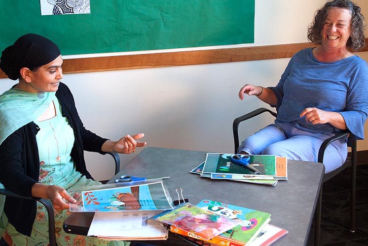 two women at a table discussion teaching aids and props