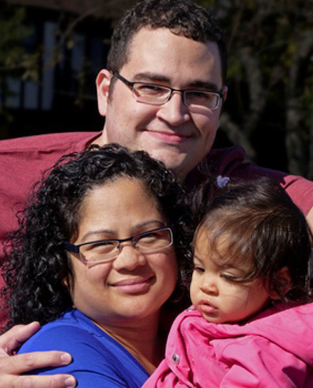 Father embraces his wife and daugther