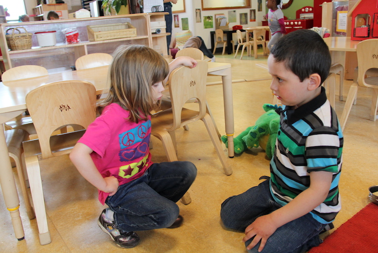 Niña y niño jugando en el aula