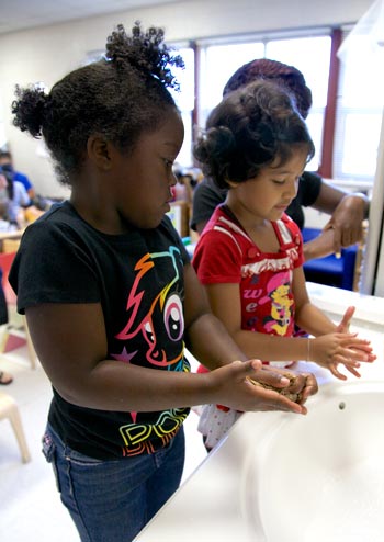 two children washing their hands