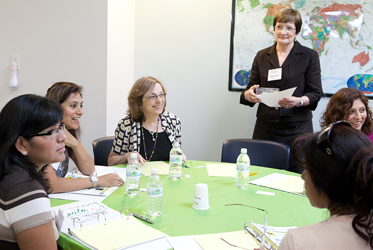 A group of people sit around a table in an office, having a meeting