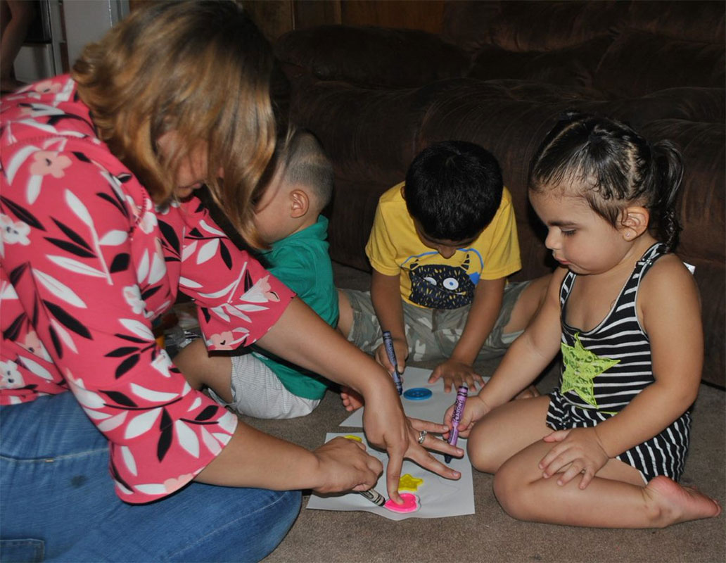 maestra de Head Start con tres estudiantes en el hogar