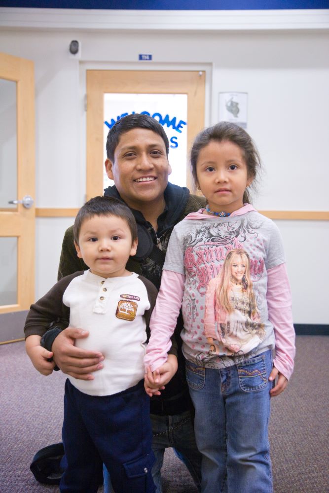 Father proudly posing with his two children.