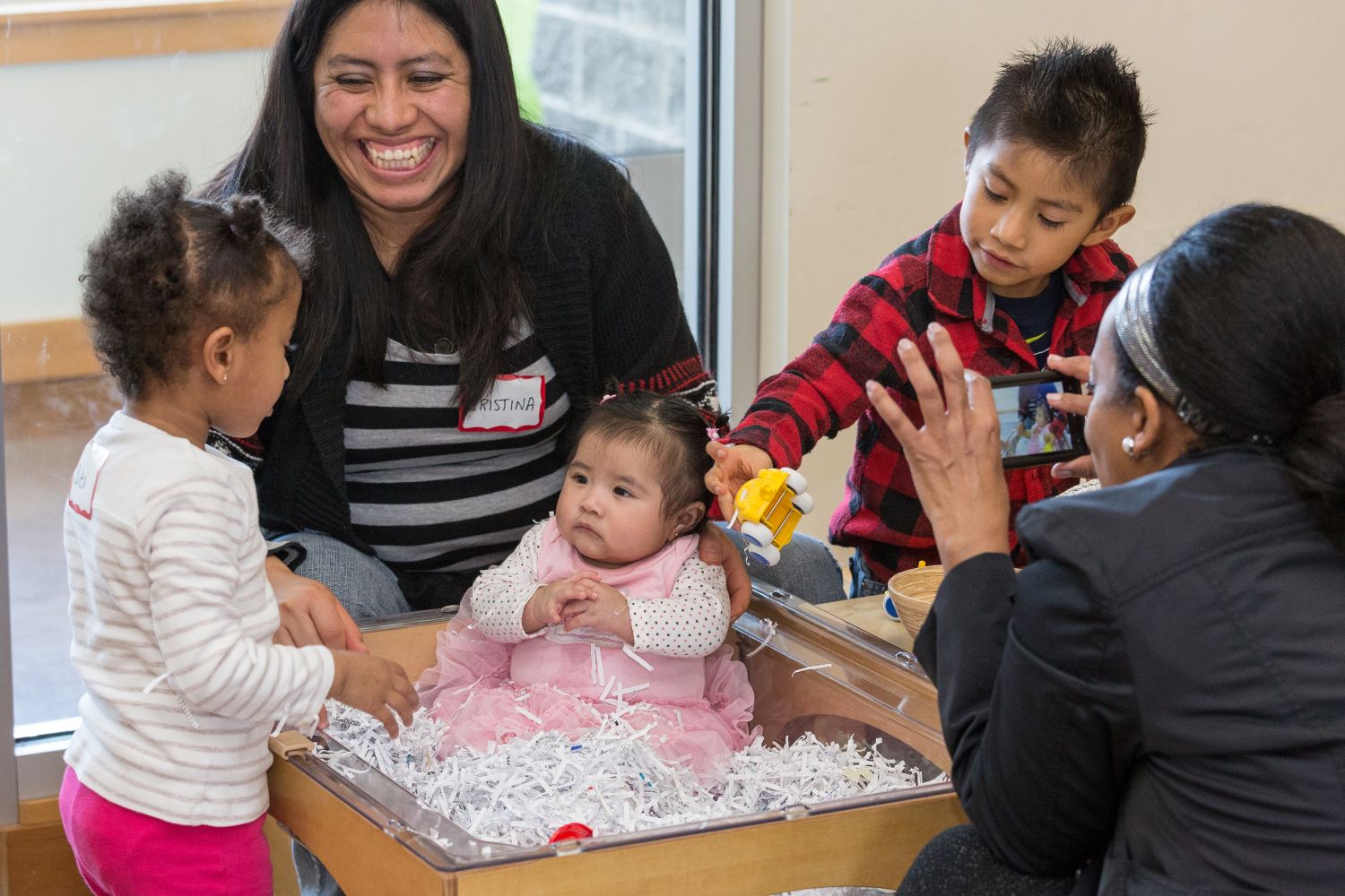 Maestras y niños pequeños entreteniendo a un bebé