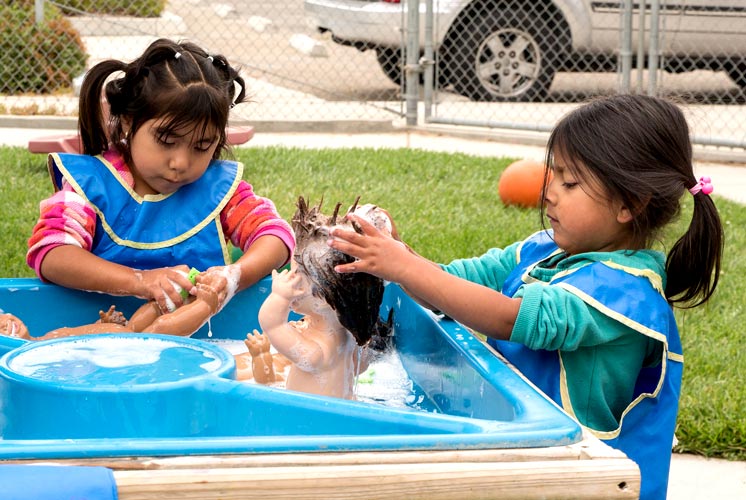 two girls batching doll