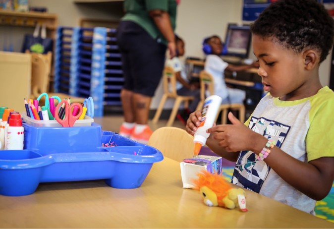 Niño pegando un proyecto de la clase