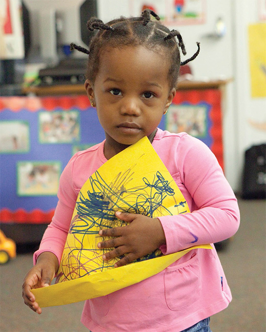 child with coloring paper