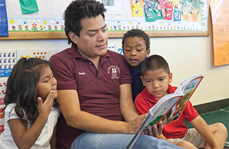 hombre leyéndoles a los niños