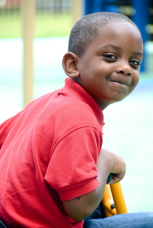 Little boy smiling and staring at the camera