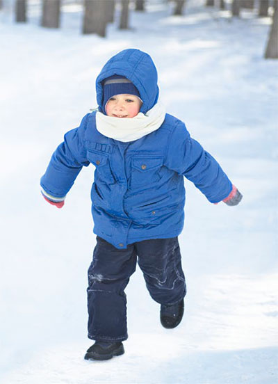 Un niñito corriendo en la nieve