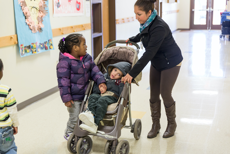 Little kid being pushed by his mom