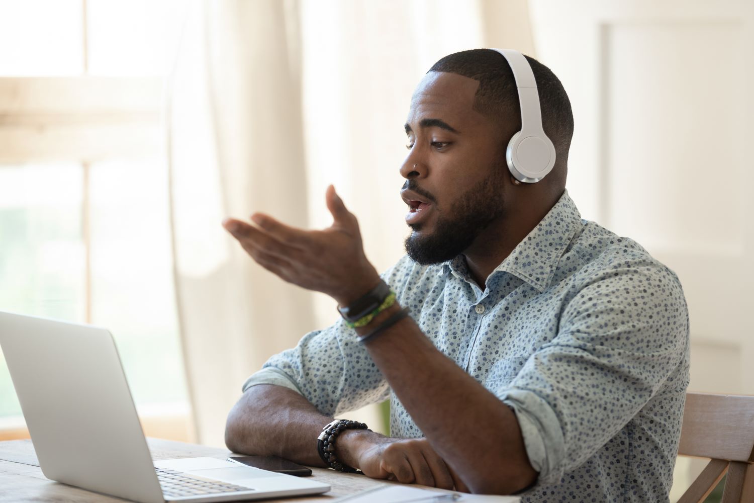 Male using laptop and wearing headphones on video chat.