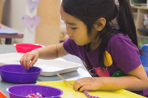 child playing with beads