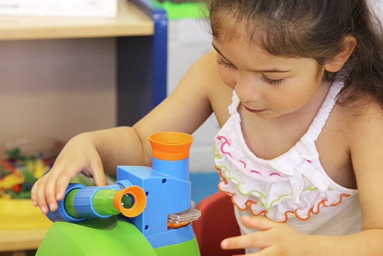 A girl adjusting a microscope