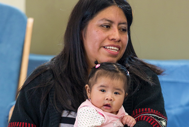 Mom holding toddler girl on her lap