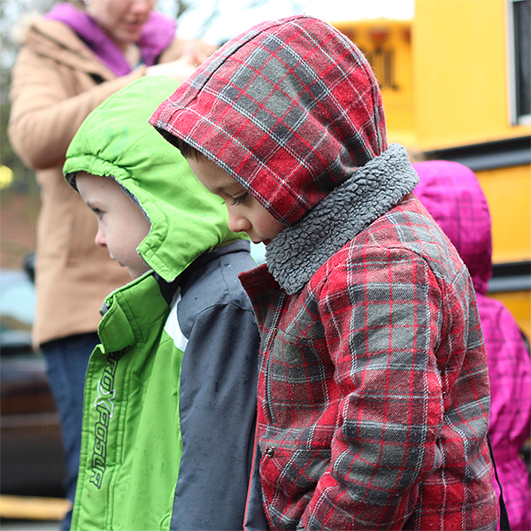 Niños pequeños caminando desde el autobús escolar