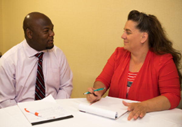 Business man and woman at a table with papers