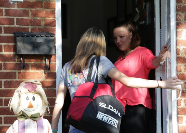 Mother opening the door for a home visitor