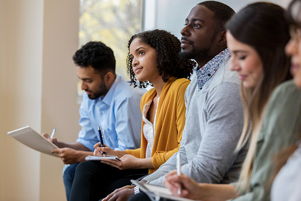 A group of people at a meeting taking notes.