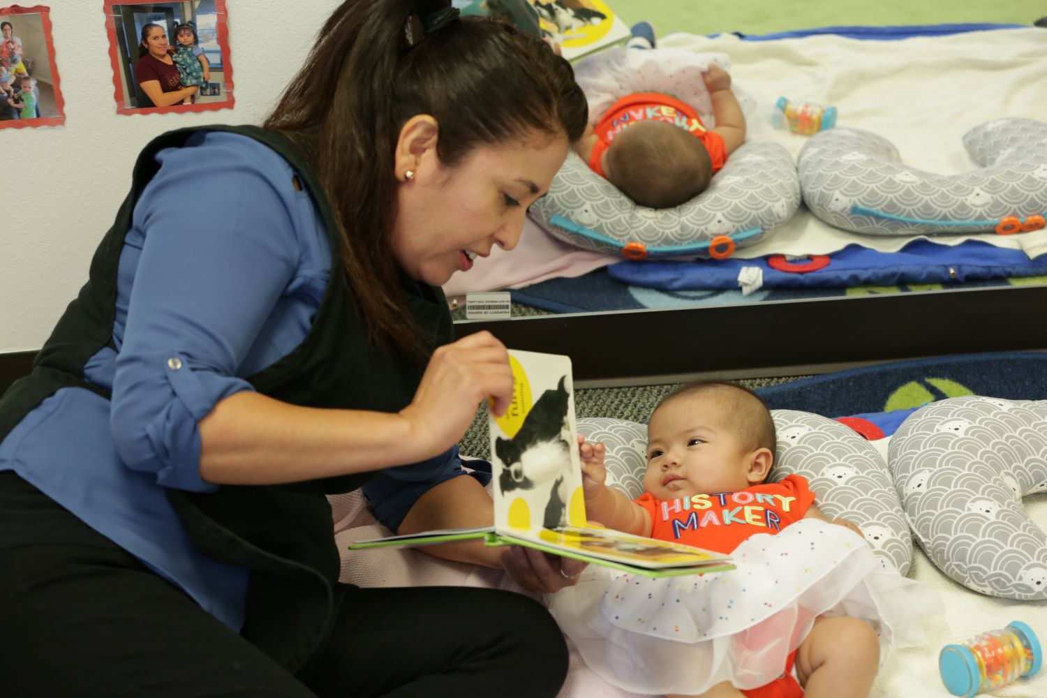 Teacher reading a book to an infant.