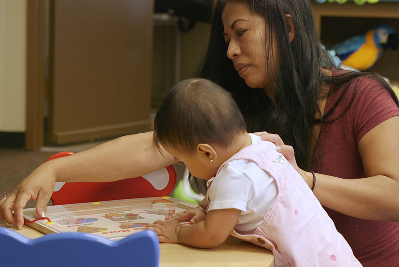 Maestra y niña pequeña haciendo actividad de aprendizaje.