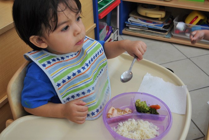 Niño pequeño comiendo con cuchara