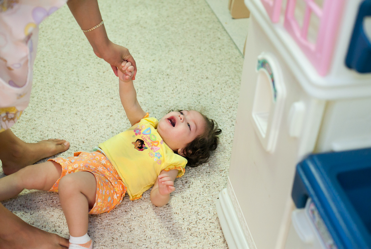 Niña pequeña tirada en el suelo