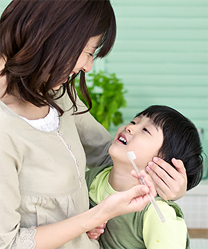 Mujer cepillando los dientes de su hijo discapacitado