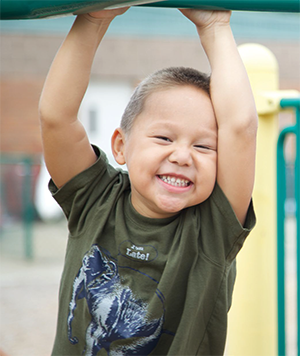 Niño pequeño balanceándose en un parque infantil