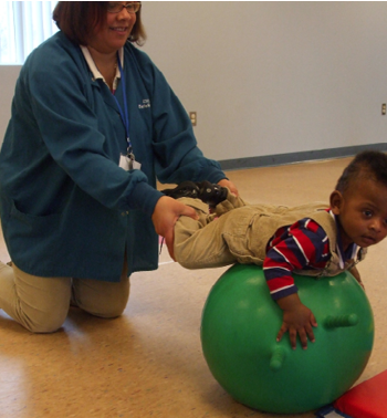 Woman holding kid while he plays