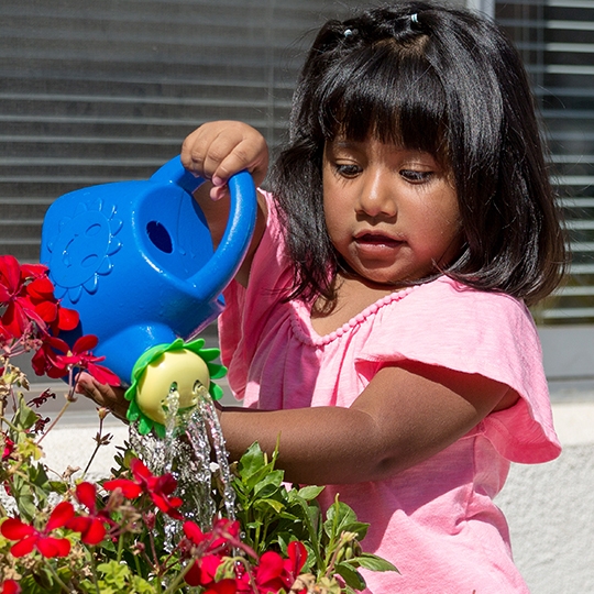 a girl waters flowers